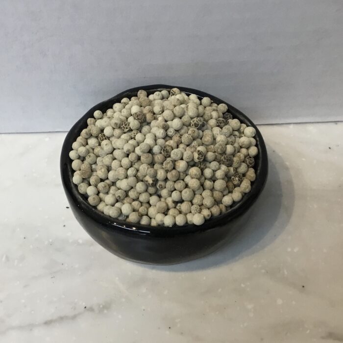 White peppercorns, the dried seeds of the Piper nigrum plant, harvested at full ripeness and outer skin removed. They have a milder flavor and a lighter color.